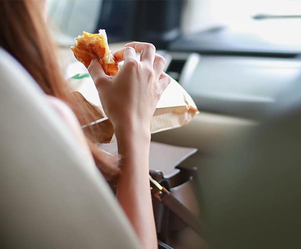 A woman eats in her car